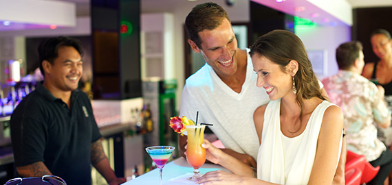 Couple having a polynesian cocktail at the bar of the Manava Suite Resort